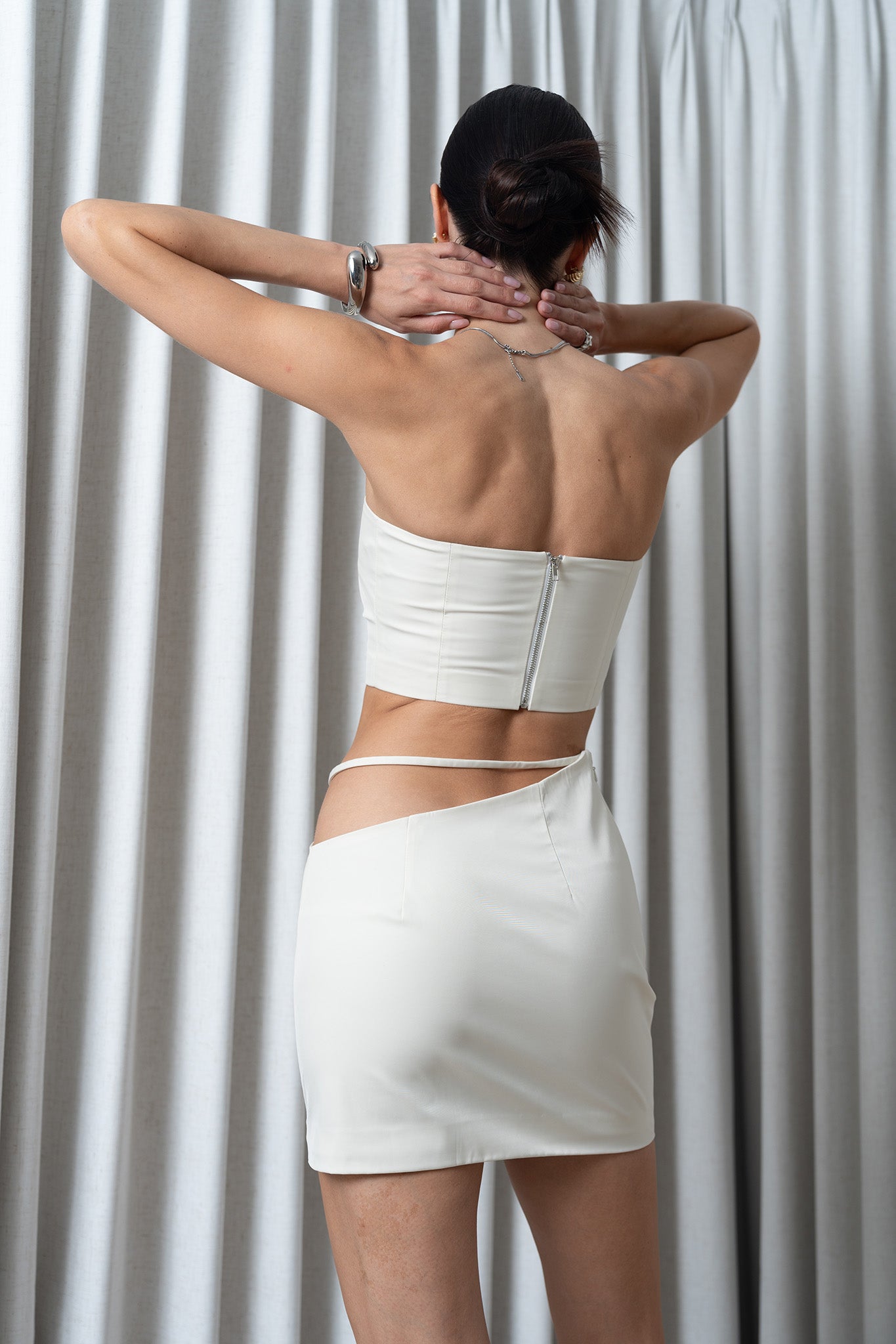 Xiaoyuan Gong New York The TENSION cutout strapless bra top paired with slim line tight mini skirt in white
